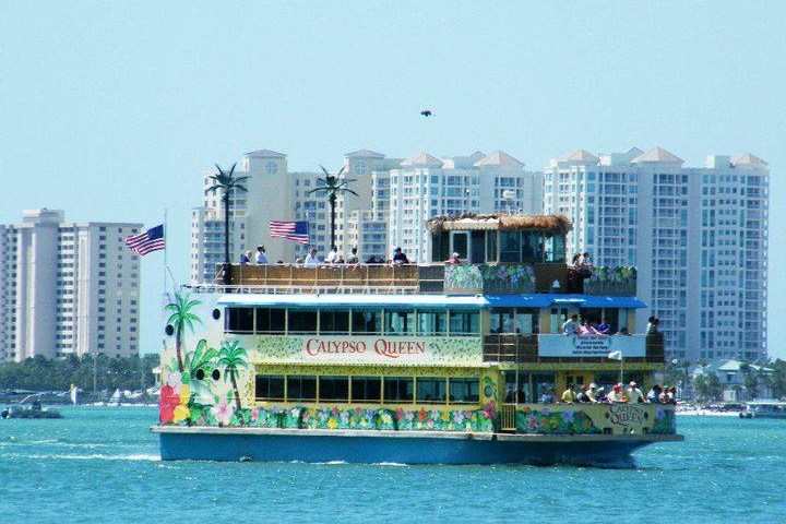 a large ship in a body of water with a city in the background