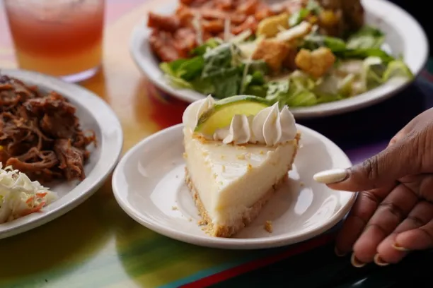 Slices of pie, salad, and drink on a colorful table.