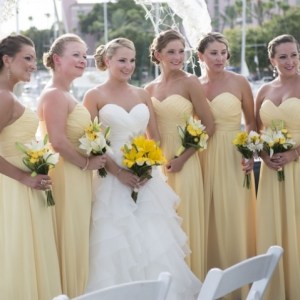 a group of people standing in front of a wedding cake