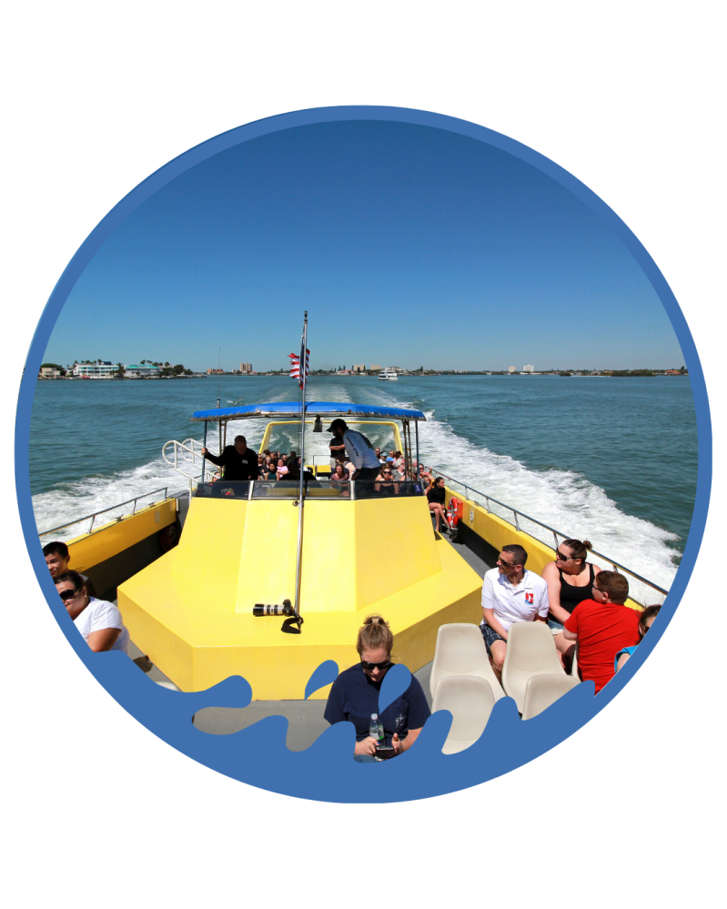 People on a yellow boat cruising on calm water under a clear blue sky.