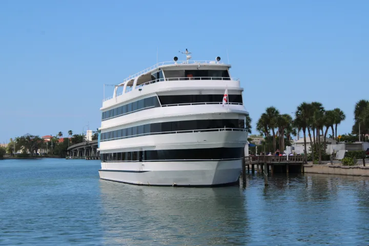 White dining cruise vessel docked in its slip.