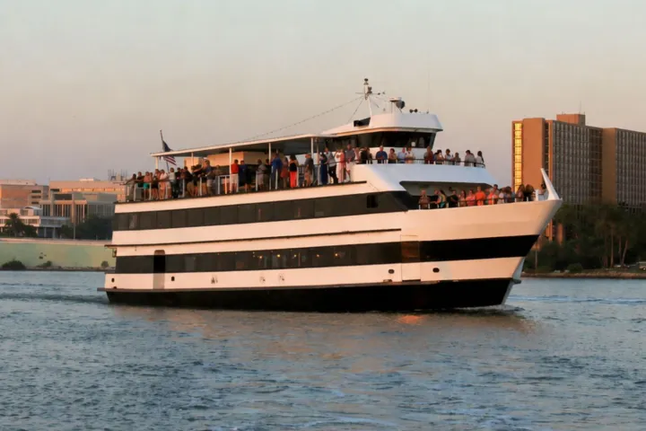 Large white ferry with multiple decks sailing on a river.