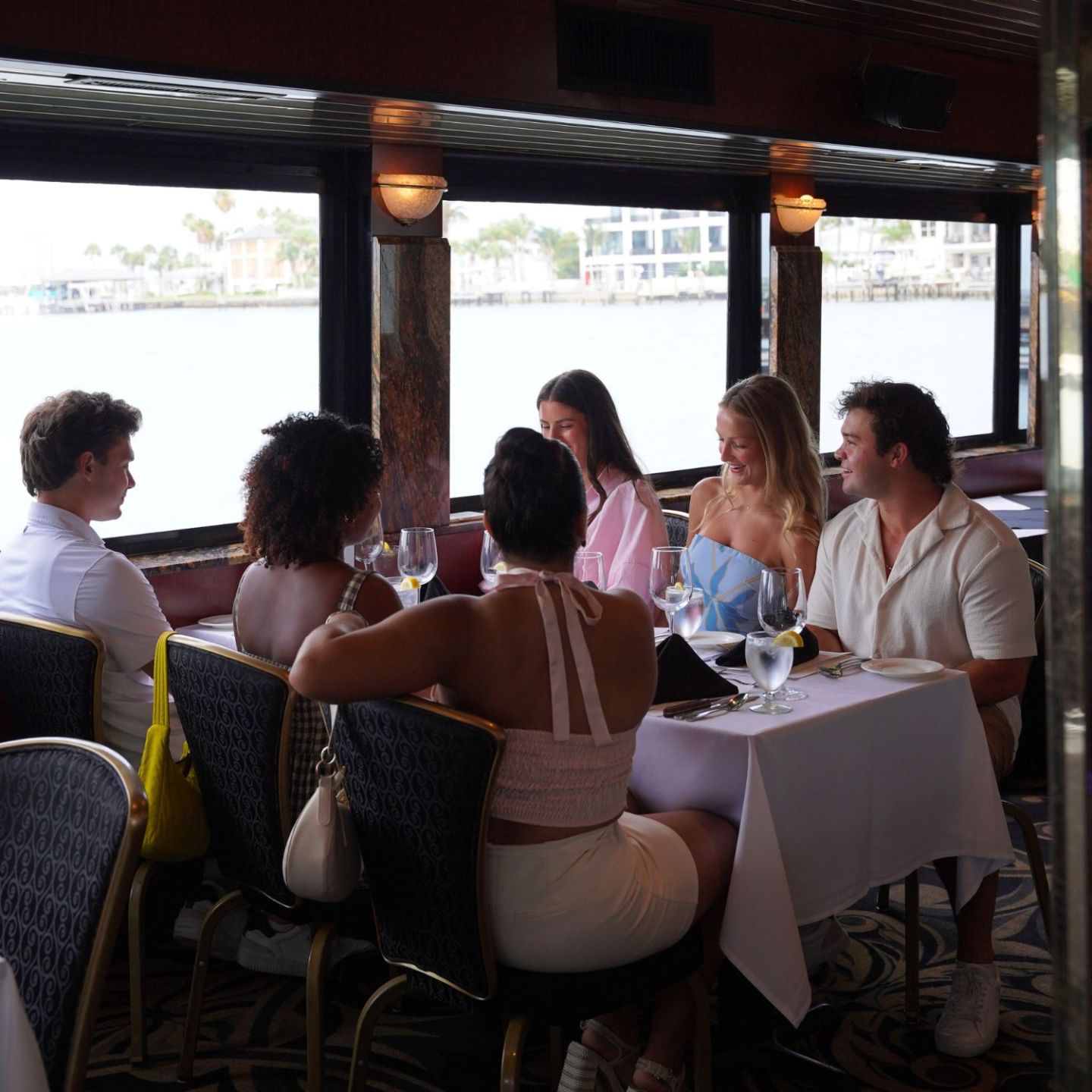 Group of people dining in a restaurant with waterfront view.