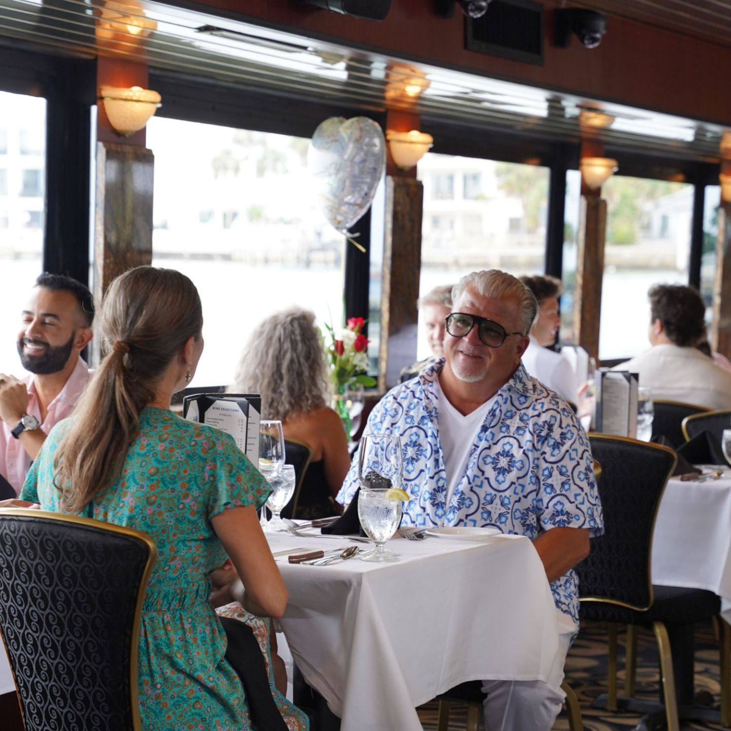People dining in a restaurant with a waterfront view.