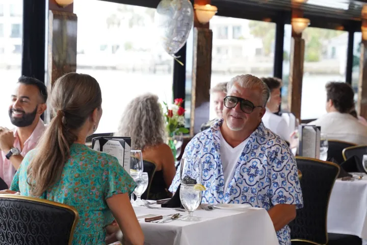 People dining in a restaurant with a waterfront view.