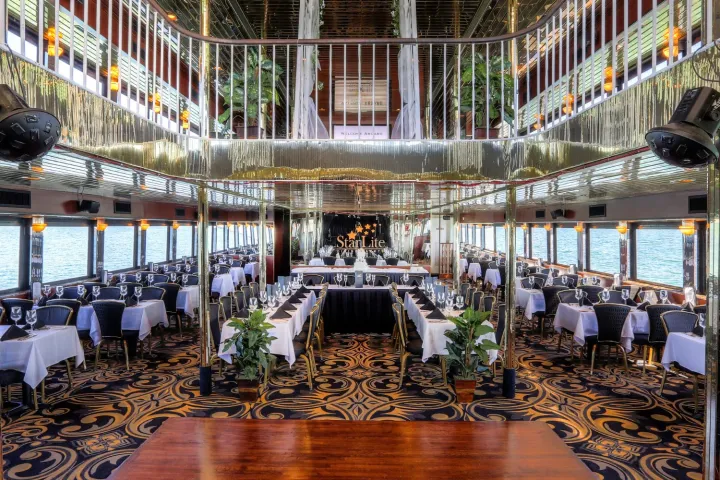 Elegant dining area on a luxury riverboat with set tables and chandeliers.