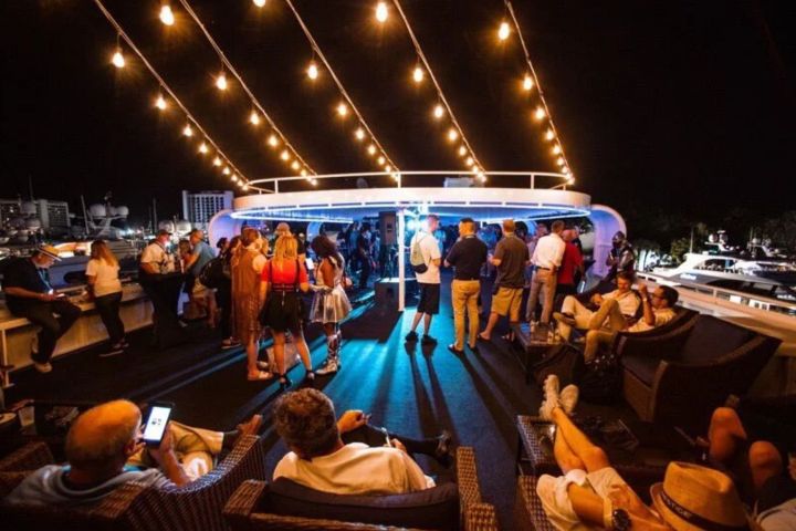 People gathered on a yacht deck at night under string lights.