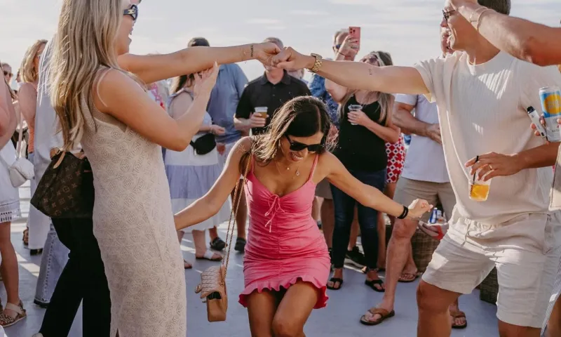 People dancing and cheering outdoors at a gathering.