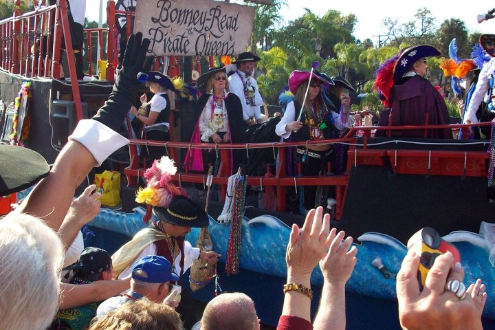 Parade with people dressed as pirates on a decorative pirate ship float.